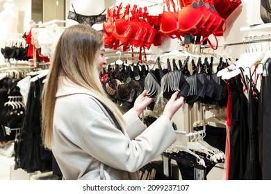 Young woman chooses a sexy bra in a lingerie store. Season of sales and discounts.