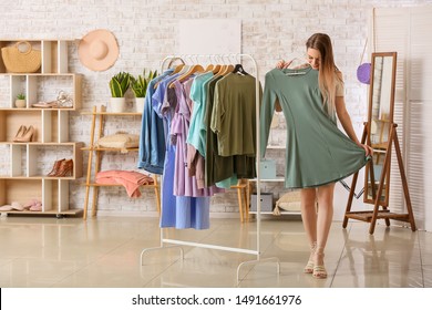 Young Woman Choosing Clothes In Dressing Room