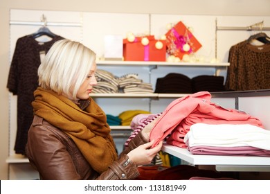 Young woman choosing clothes in the shop