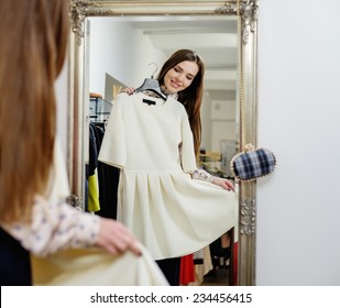 Young Woman Choosing Clothes In A Showroom 