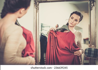 Young Woman Choosing Clothes In A Showroom 