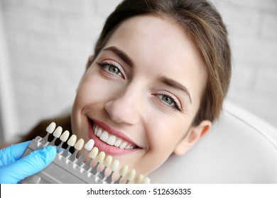 Junge Frau, die sich für Zahnfarbe beim Zahnarzt entscheidet