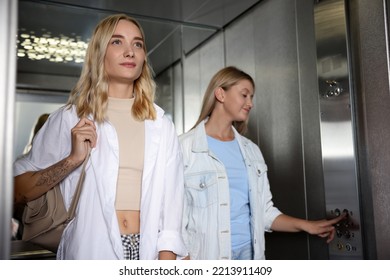 Young Woman Choosing Floor In Modern Elevator