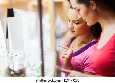 Young Woman Choosing Jewelery In Shop