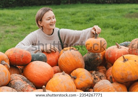 Young woman choosing pumpkins at farm shop. People sustain farm production by buying products at local market. Sustainable lifestyle concept. Autumn harvest products market