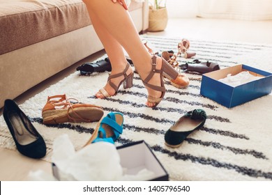 Young Woman Choosing Summer Shoes And Trying Them On At Home. Hard Choice To Make From Sandals, Heels And Flats. Daily Decision