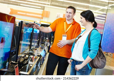 Young Woman Choosing Tv Set With Shop Assistant In Home Appliance Shopping Mall Supermarket