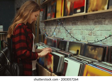 Young woman choosing vinyl records in store - Powered by Shutterstock