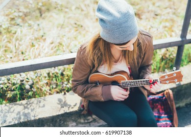 Young Woman In The City Playing Ukulele - Busker, Musician, Composer Concept