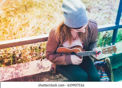 Young Woman In The City Playing Ukulele - Busker, Musician, Composer Concept - Filtered Colorful