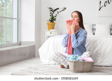 Young Woman With Clean Laundry At Home