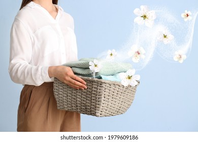 Young woman with clean laundry on color background - Shutterstock ID 1979609186