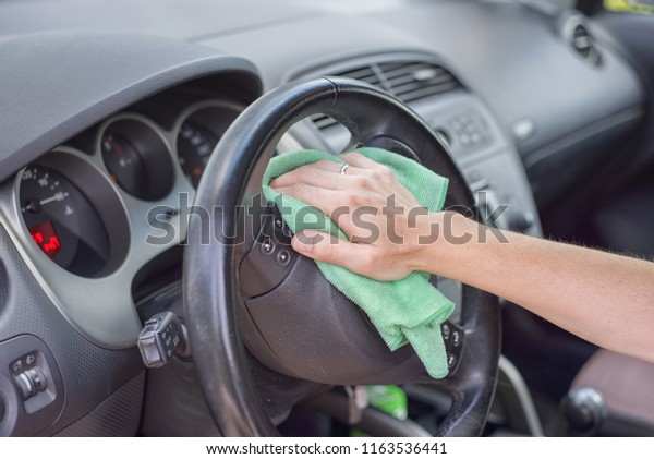 Young woman cleaning car interior with\
microfiber cloth. Car\
detailing.