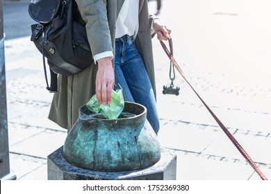 Young Woman Cleaning Dogs Excrement On Street, Pet Owner Picks Up Dog's Poop Cleaning Up Mess.