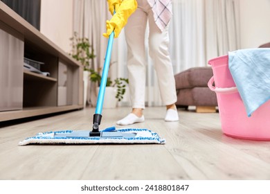 young woman cleaning floor with wet mop at home , daily housekeeping , close-up - Powered by Shutterstock