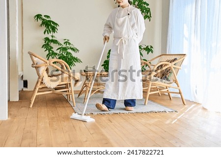 Young woman cleaning the flooring in the room