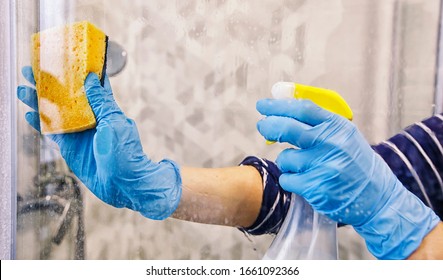 The Young Woman Is Cleaning The Glass In The Shower Stall