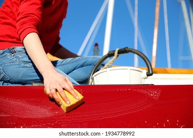 A young woman cleaning her boat