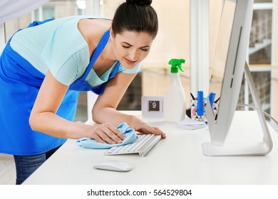 Young Woman Cleaning Keyboard In Office