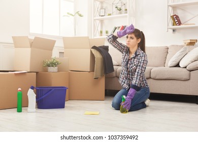 Young Woman Cleaning New Appartment With Rag And Detergent In Living Room Full Of Moving Young Woman Cleaning New Appartment With Rag And Detergent In Living Room Full Of Moving