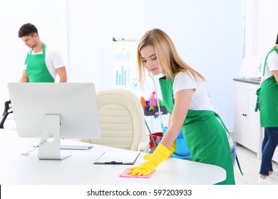 Young Woman Cleaning Office Table