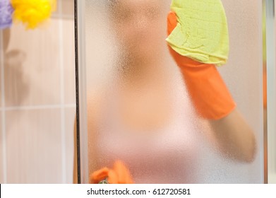 Young Woman Cleaning Shower Door