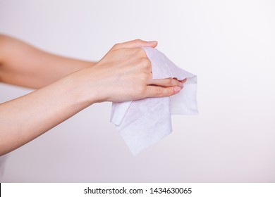 Young Woman Cleaning Skin Of Two Hands With Wet Wipes, White