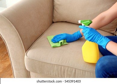 Young woman cleaning sofa with duster, closeup - Powered by Shutterstock