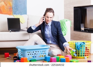 Young Woman Cleaning Up Toys And Working From Home