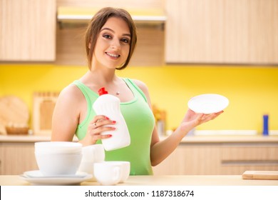 Young Woman Cleaning And Washing Dishes In Kitchen