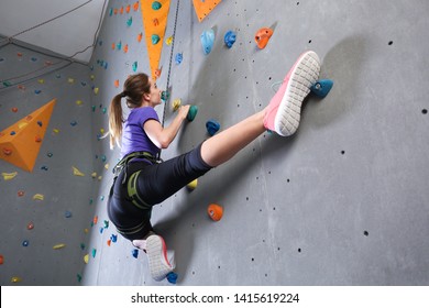 Young woman climbing wall in gym - Powered by Shutterstock