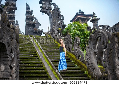 A young woman climbs the ancient steps to the Buddhist temple.