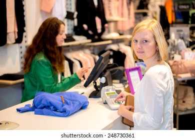 Young Woman In The Clothes Shop Over The Counter