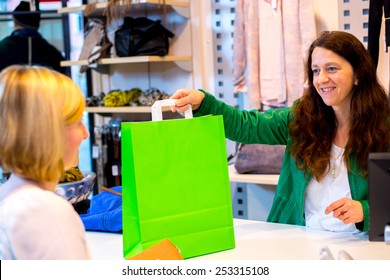 Young Woman In The Clothes Shop Over The Counter