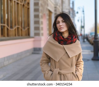 Young Woman In A Coat Walking On The Street.