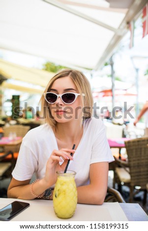 Young Woman with cocktail in street cafe