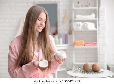 Young Woman With Coconut Oil For Hair In Bathroom