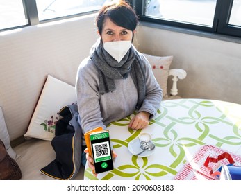 Young Woman In Coffee Bar Holding Smartphone With Qr Code Confirm Vaccination Coronavirus Covid-19. Vaccine Done With Digital Green Pass Passport