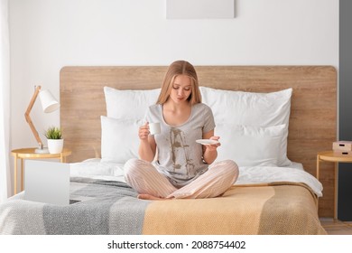 Young Woman With Coffee Stains On Her T-shirt In Bedroom