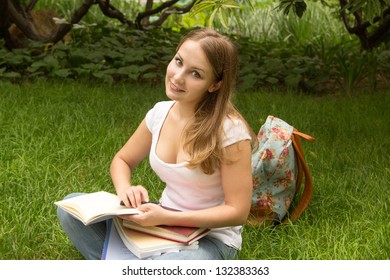 Young Woman College Student With Book And Bag Studing In A Park