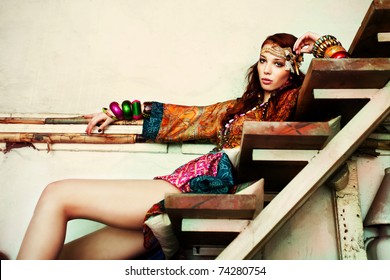young woman in colorfull summer clothes sit on stairs indoor shot