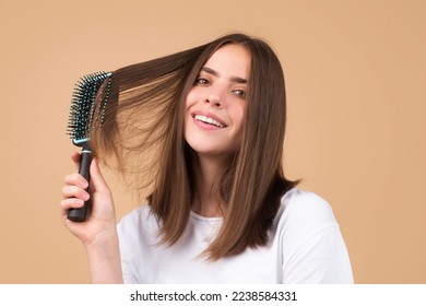 Young woman combing healthy and natural shiny hair, isolated on studio. Beauty hair care. - Powered by Shutterstock