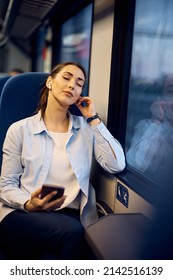 Young Woman Commuting By Train And Listening Music With Her Eyes Closed.