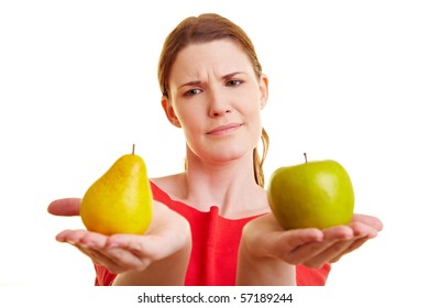 Young Woman Comparing An Apple And A Pear