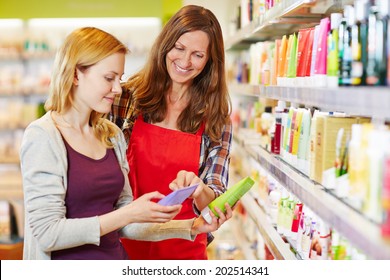 Young Woman Comparing Cosmetics Products With Saleswoman In A Drugstore