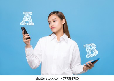Young woman comparing smartphone A with smartphone B.