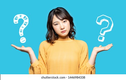 Young woman comparing with two things. - Shutterstock ID 1446984338