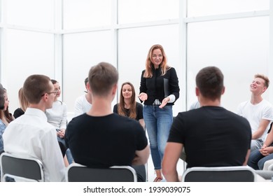 young woman conducts business training with a group of young people.