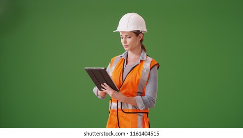 Young woman construction manager using tablet device on green screen - Powered by Shutterstock