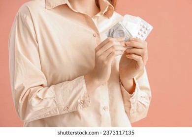 Young woman with contraceptives on pink background, closeup - Powered by Shutterstock